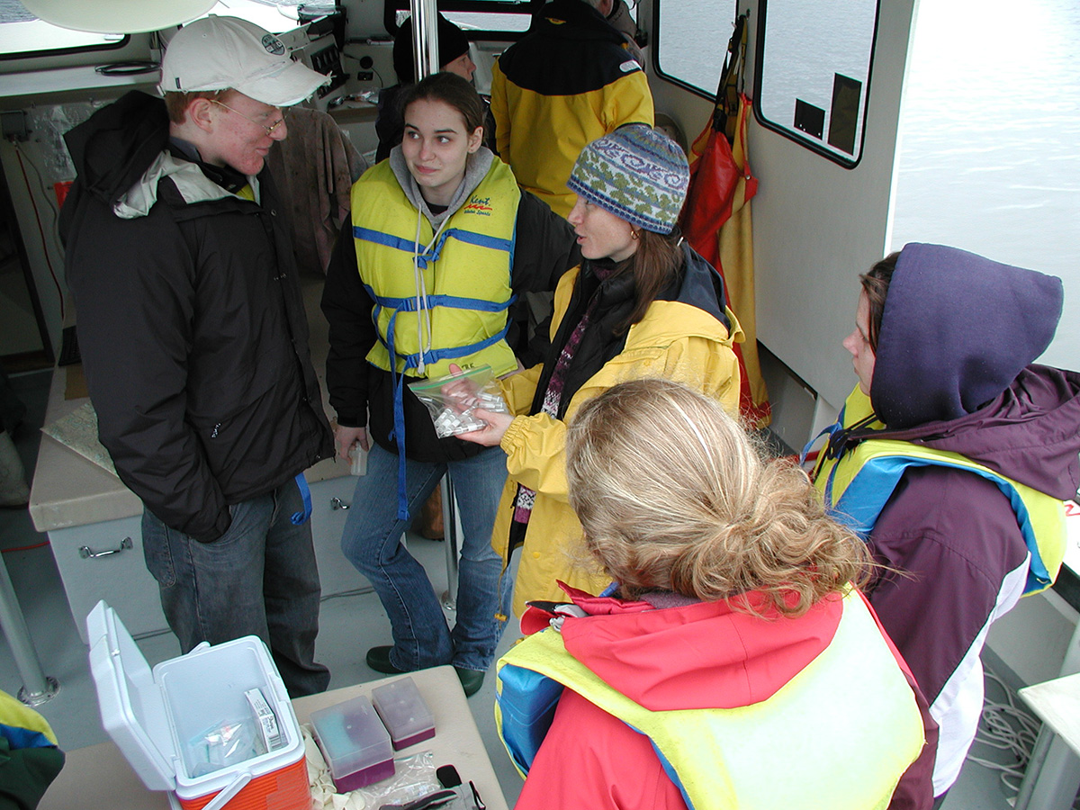 Students speaking with an instructor on a boat.