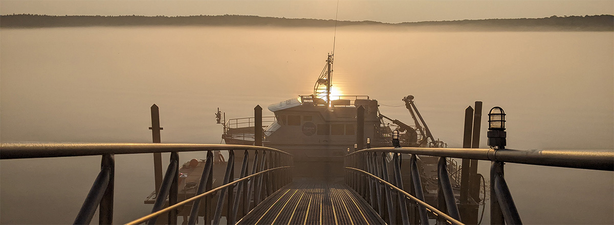 RV Bowditch at the dock with fog and sunlight reflection