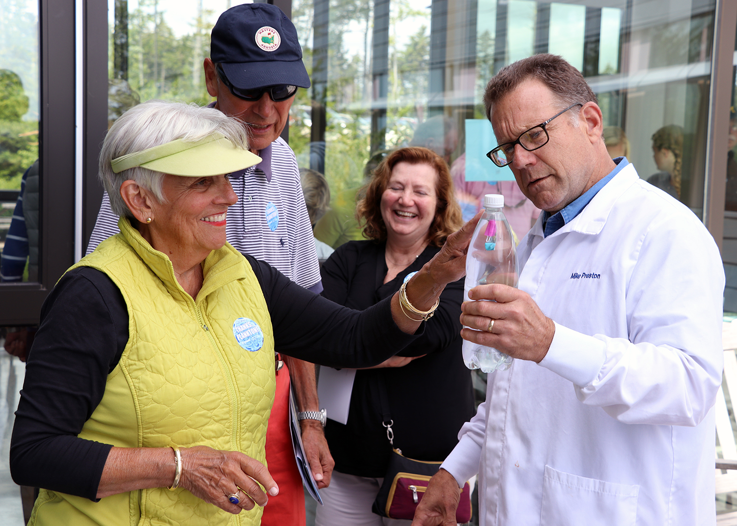 Scientist showing visitors experiment.