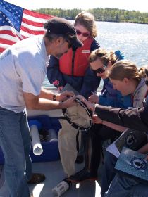 Instructor showing students experiment on boat.