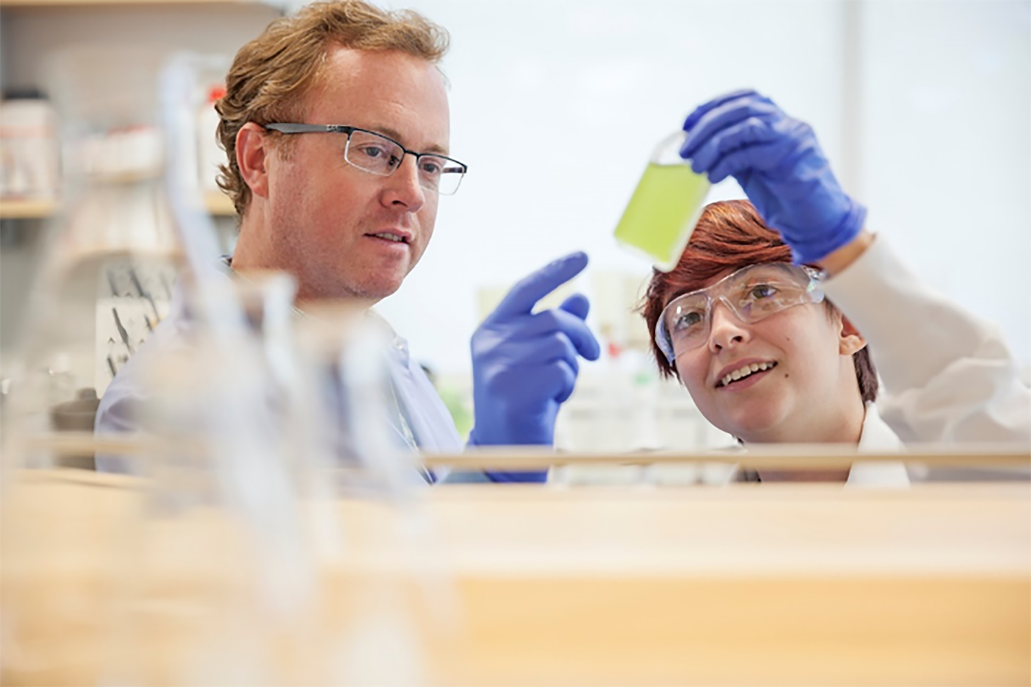 Scientist teaching a student in laboratory.