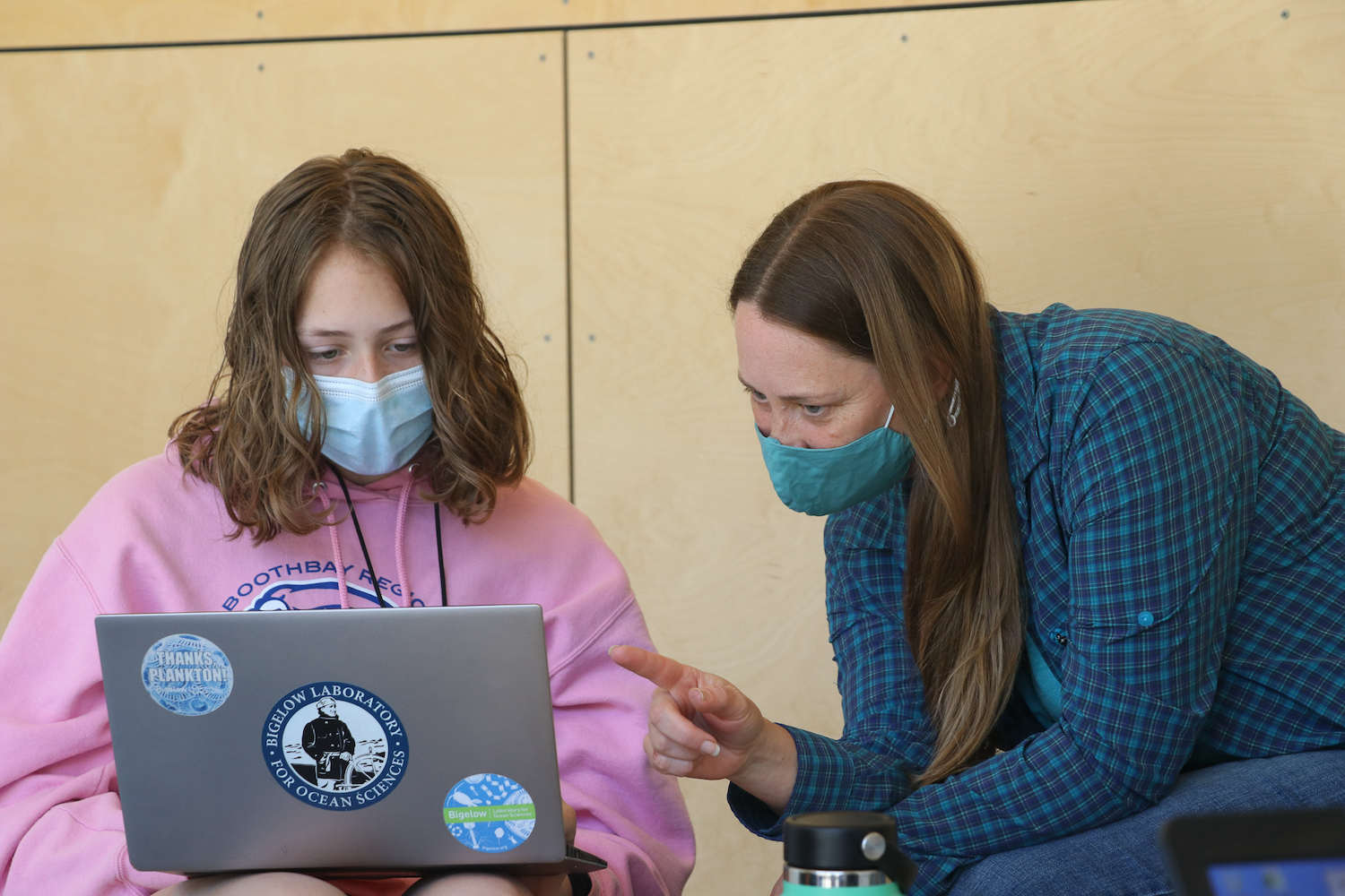 Instructor teaching student with laptop