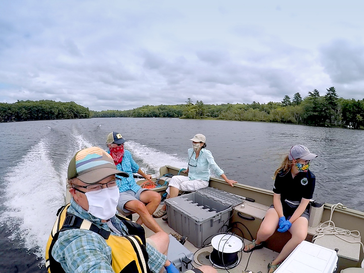 Scientists in surgical masks on the stern of a boat