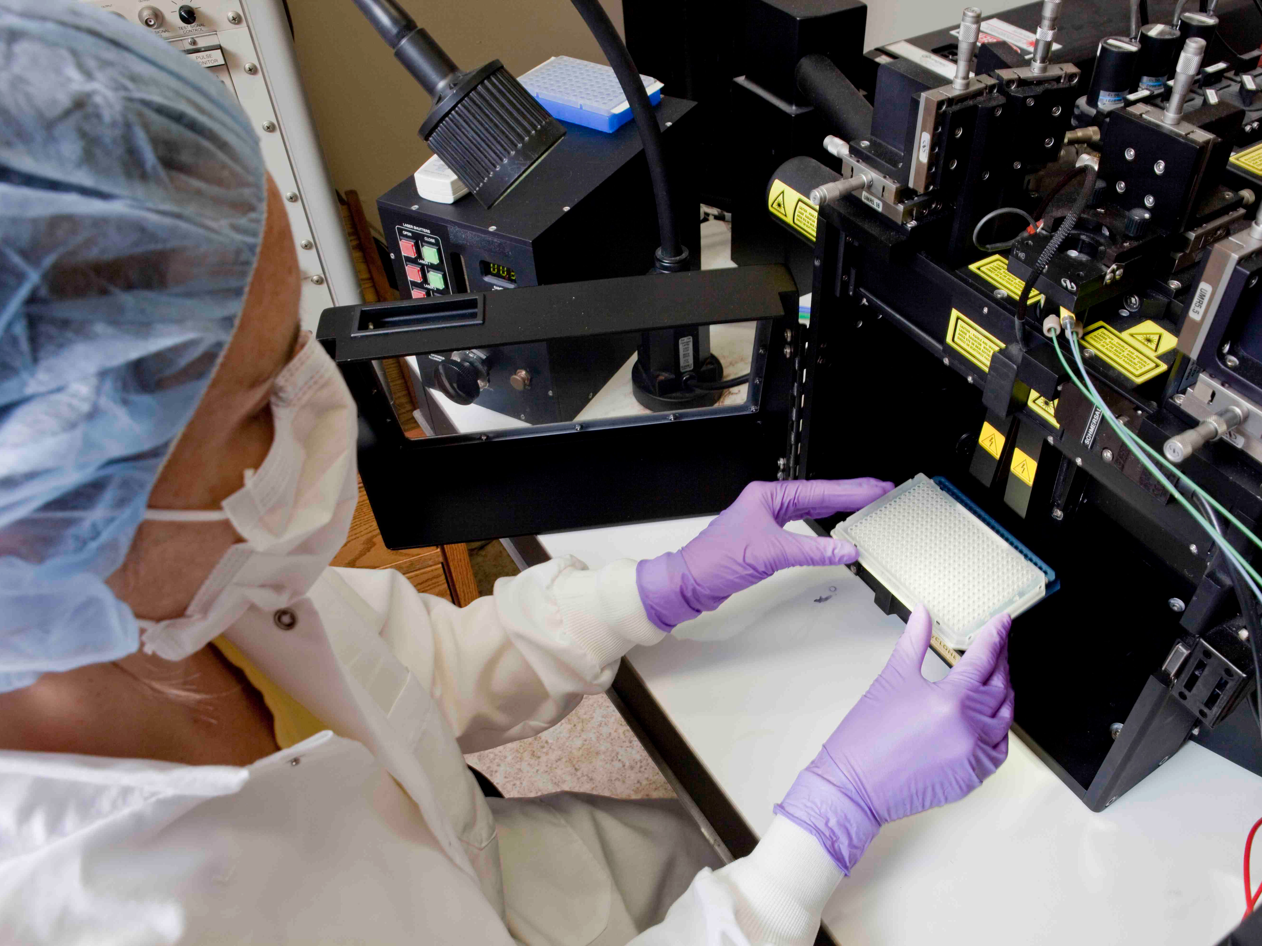 Scientist loads material for analysis into an instrument