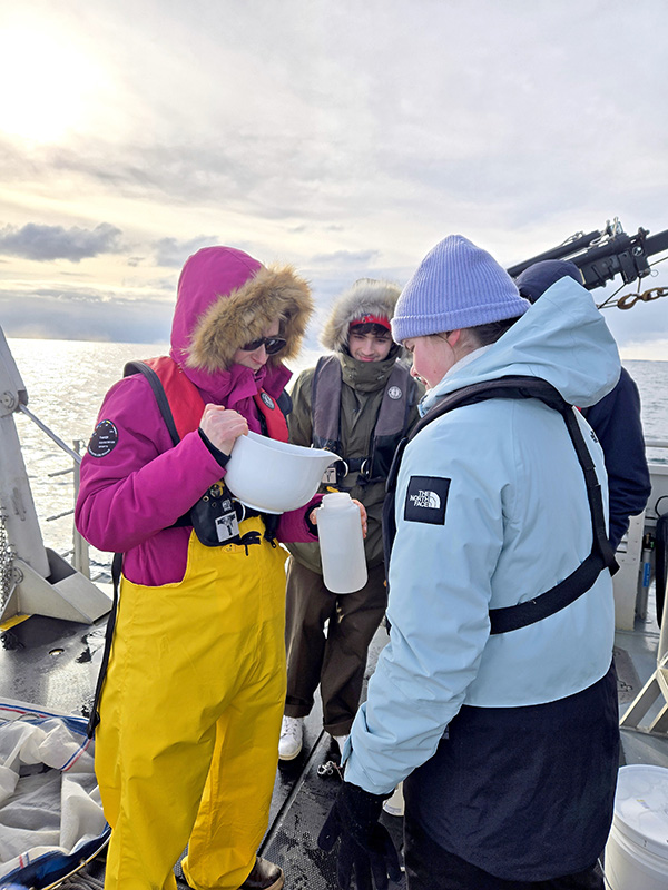 students in winter clothing collecting samples from the deck of R/V Bowditch