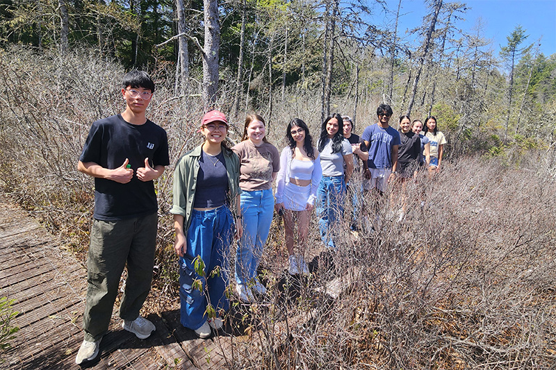 a line of students on a path in a wooded area