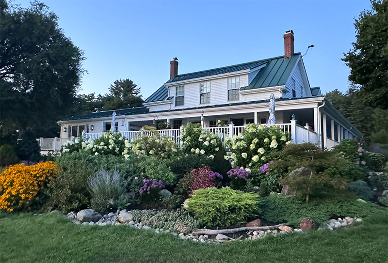 Low angle shot of a Maine cottage and gardens