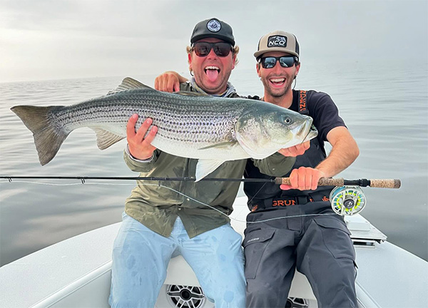 two men in a boat holding a fish