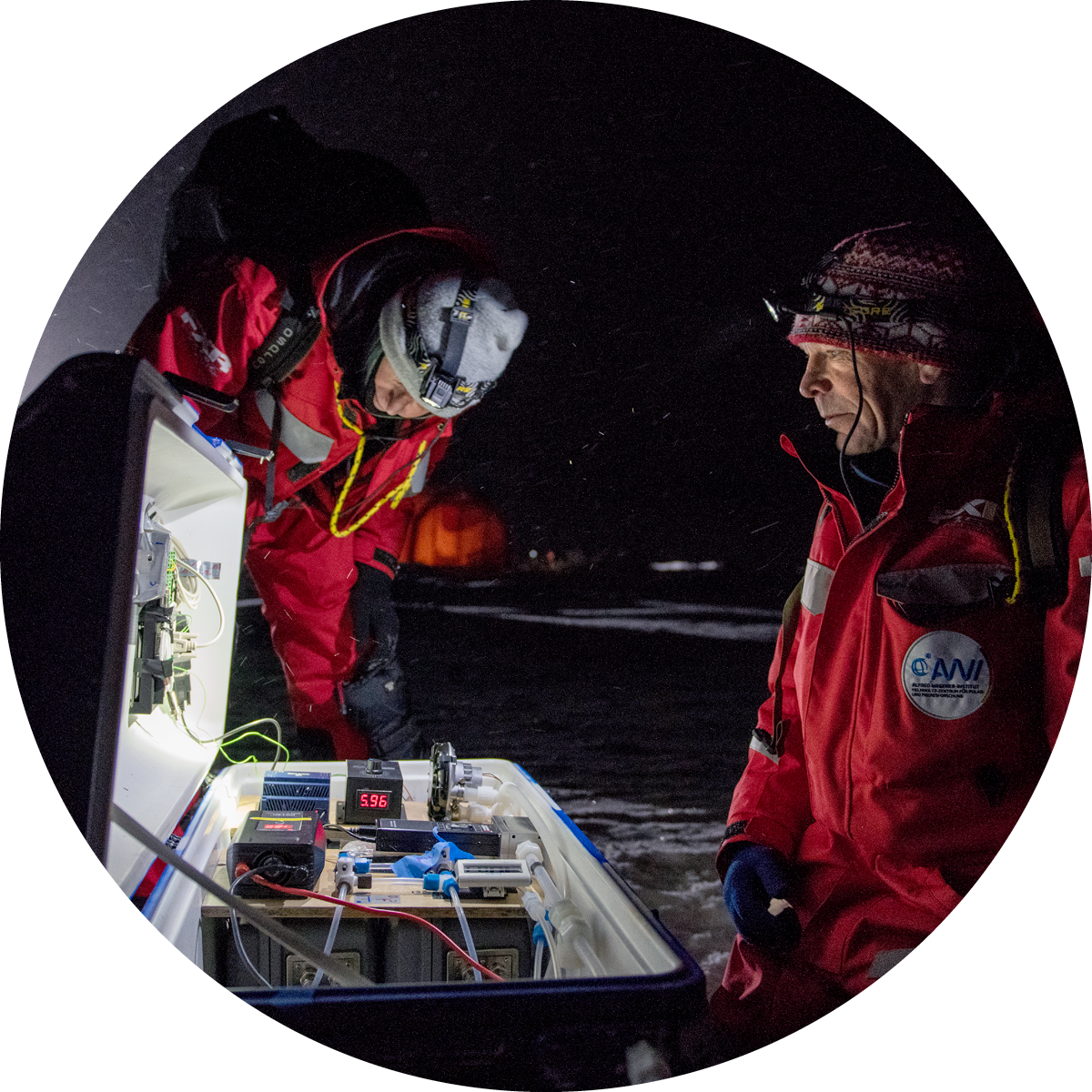 Two scientists performing an experiment outside at night.