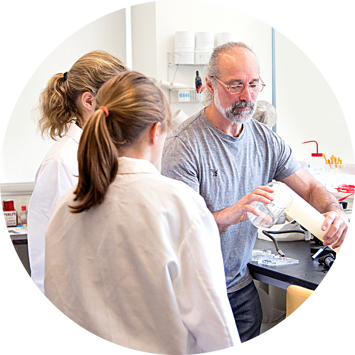 Scientist showingn two students an experiment